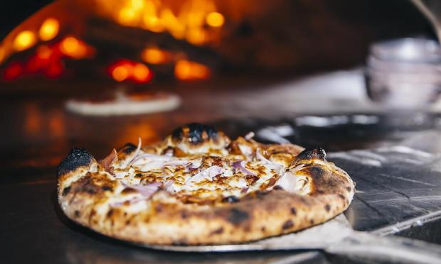 Una pizza, saliendo del horno. (GETTY)