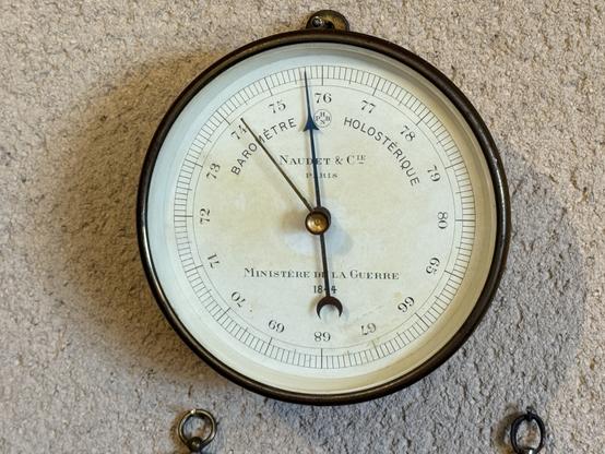 Photo of an old needle barimeter mounted on a plaster wall