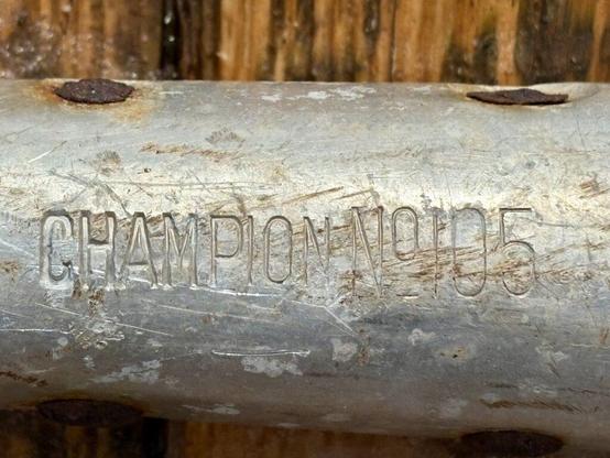The word Champion No 105 imprinted on the shank of a metal shovel.
