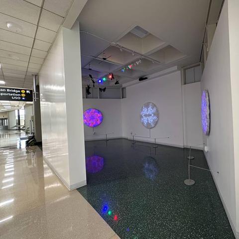 LED art panels (48" to 60" diameter) on display in airport gallery