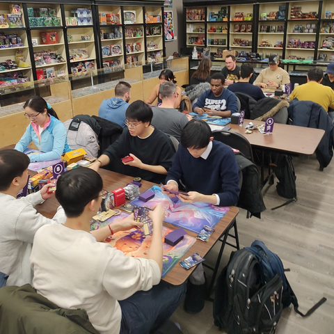 2 dozen people playing Disney's Lorcana Trading Card Game in the Hairy Tarantula store