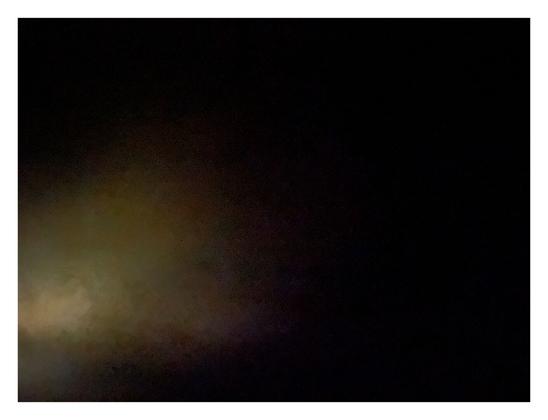 The first photo is almost totally dark, with a bit of yellow blurry light shining in the lower left corner.