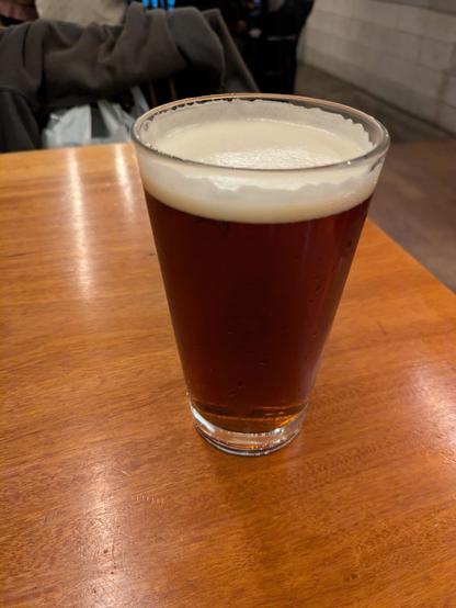 A glass of brown ale on a table
