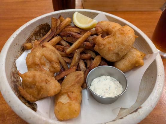 A ceramic bowl filled with fish and chips