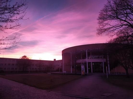 Das Bild zeigt das Konrad-Zuse-Medienzentrum am Campus der BTU in Senftenberg während eines Sonnuntergangs.
