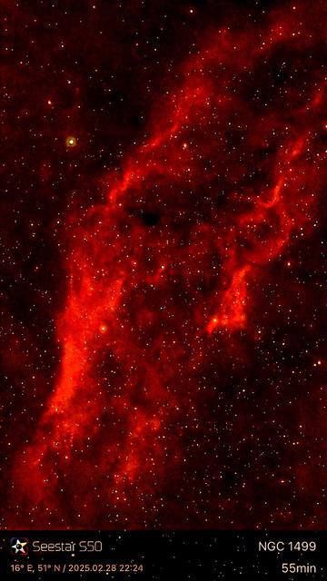 An astrophotograph of the California Nebula (NGC 1499), displaying vibrant red hues surrounded by countless stars. The image captures the intricate dust and gas structures in space, with a timestamp and equipment reference at the bottom.

Astrofotografia Mgławicy Kalifornia (NGC 1499), przedstawiająca żywe czerwone odcienie otoczone niezliczonymi gwiazdami. Obraz przedstawia skomplikowane struktury pyłu i gazu w przestrzeni, ze znacznikiem czasu i odniesieniem do sprzętu na dole.