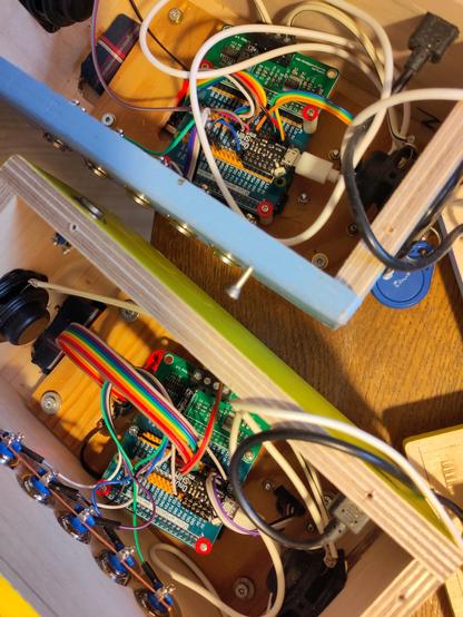 Zwei geöffnete Holzkisten mit Kabeln und Platinen. Eine ist ein Raspberry Pi mit Micro SD Karte die kaum erreichbar angebracht ist.