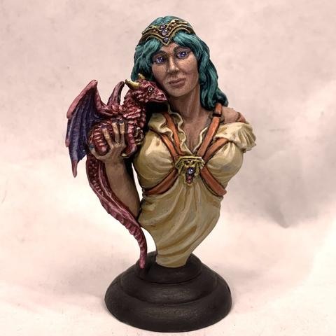 Bust of a woman holding a small pink and indigo dragon up to her face as if listening to it whisper. They look off to the right. She has long, silky teal hair, blue eyes, and wears a cream-colored frilly shirt. Over the shirt is a red leather harness with a gold medallion over her heart. She also wears a gold tiara.