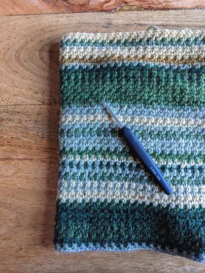 Part of a crocheted blanket with a green and yellow colour palette.