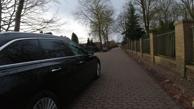 Ein Mensch in einem Auto steuert sein Fahrzeug mit zu geringem Sicherheitsabstand an einem Menschen auf einem Fahrrad vorbei.