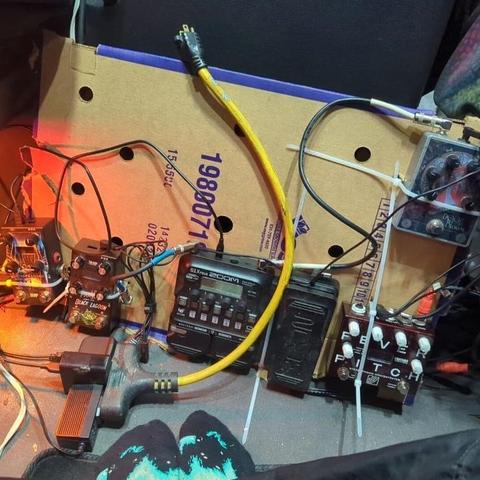 pedalboard now sitting on it's side leaning against something. power extension cord unplugged and thrown over the board.