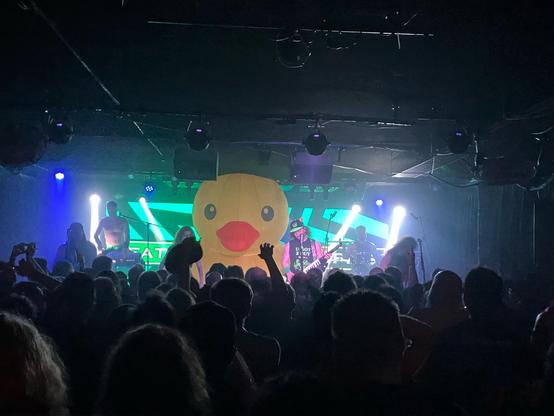 Alestorm in concert. A heavy metal band is playing live. A giant inflatable rubber duck is on stage.