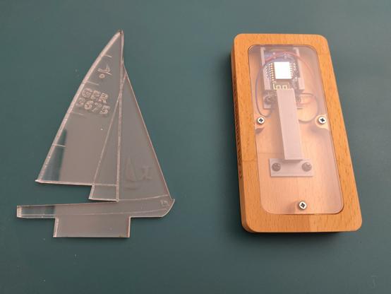 Vor dem Zusammenbau: gelasertes Segelboot aus Plexiglas und der fertige Sockel mit eingebautem ESP von unten