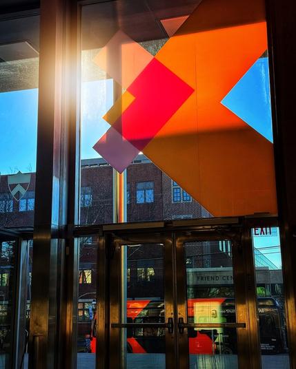 Sun shines through colored chevrons on glass