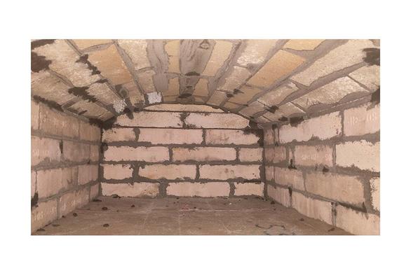 Oven interior with flat vault. Smoke outlet at the back left of the combustion chamber. Wall and arch made out of fireclay bricks.