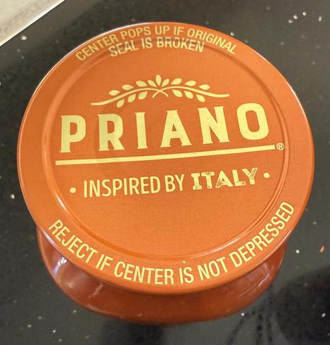 A pasta sauce jar label is a sign for the times… the lower edge says “Reject if center is not depressed”

The top says “center pops up if original seal is broken”
The middle says the brand name “Priano - inspired by Italy”