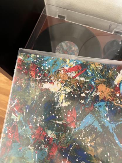 Holding the album cover with an abstract painting by Tiff Davis while the record is playing in the background.