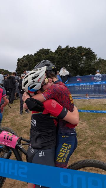 Competitors in the varsity girls race hug at the finish