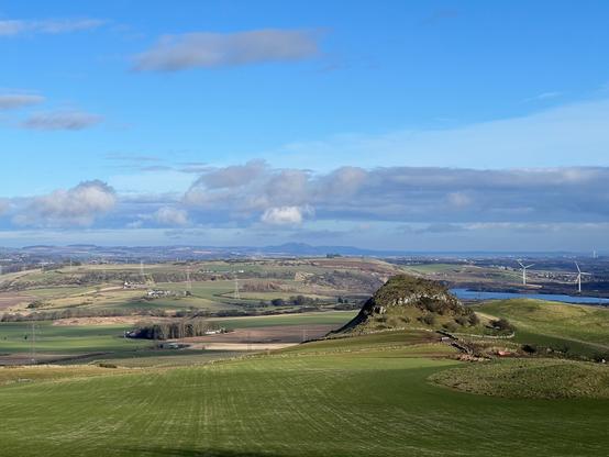 View over the landscape with wind turbines and a bit of Loch Ore business in the background. Dunmore Fort in the foreground.