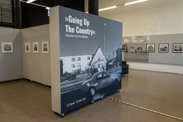 Coverbild der Ausstellung 'Going Up The Country' von Peter Rathmann im Ausstellungsraum der GAF. Eine Straßenszene in Schwarz-Weiß.
