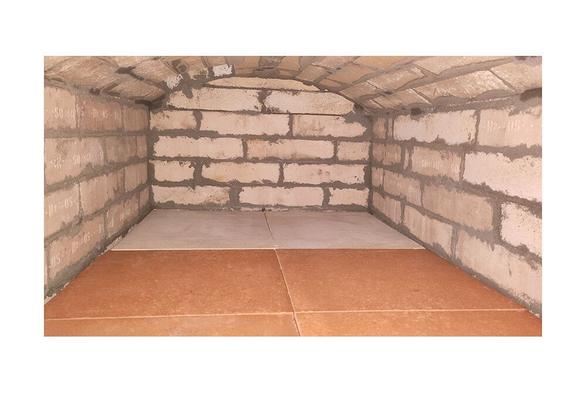 Oven interior with flat vault. Smoke outlet at the back left of the combustion chamber. Wall and arch made out of fireclay bricks. Bottom of the oven lined with special fireclay baking plates.