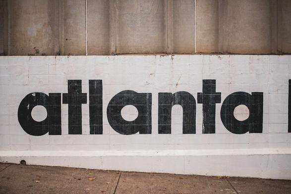 "atlanta" painted in black on a white wall.