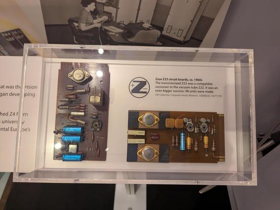 A small museum display with 2 brown boards with huge discreet electric elements soldered to them and only very few connecting pins on the edge of the board visible.
Above one of the cards is a small text describing the z23:

"Zuse Z23 circuit boards, ca. 1960s

The transistorized Z23 was a compatible successor to the vacuum tube Z22. It was an even bigger success: 98 units were made.

SAP Collection, Computer History Museum, 102668242, 102711701"