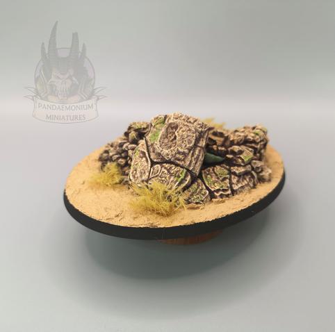 The chimera's base with a sandstone rocky outcrop, desert sand and dried scrub