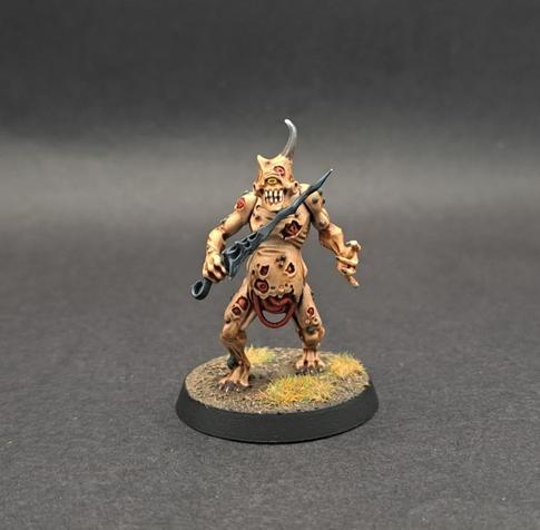 A Plaguebearer. It's body is a pale sepia colour, with red muscle showing through in rips in the skin. It has intestines showing through a hole in its belly