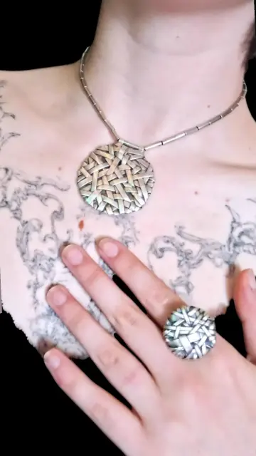 Person wearing a necklace and a ring in silver