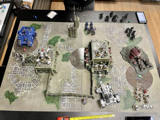 Bird’s view of Warhammer 40K battle field with t’au and ultramarines forces on opposite sides of the board.