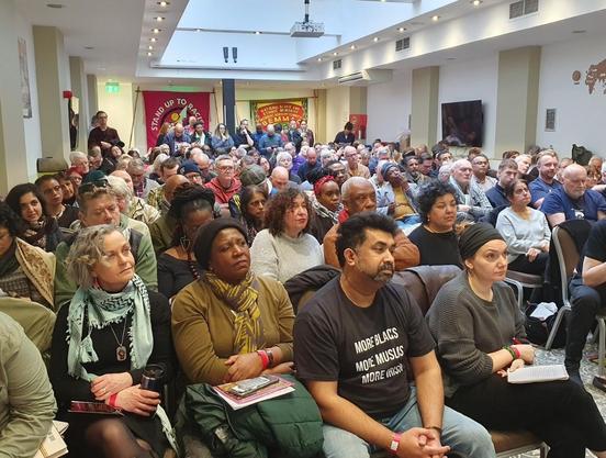 An ethnically diverse crowd, comprised of both younger and older people, seated at the conference organized by UK-based organization, Stand Up To Racism.