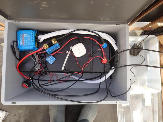 A box with a lifepo battery and various measurement devices. On the right is the raspberry pi in a separate box.