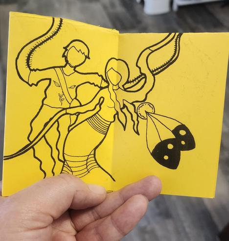 Mini zine by Danilynn Jiibay. Pages 4 and 5 as one image.

Depiction of trans man and trans woman dancing and enjoying the day. A two spirit feather emblem is also on display. All in woodland art style.