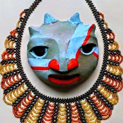 A little goat face with a beaded necklace.