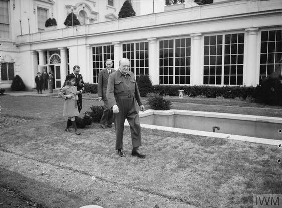 Mr Churchill, complete in his air-raid suit, which he announced to the press and cinema men present was his quote siren suit unquote, demonstrates how he runs to the air raid shelter.

British Prime Minister Winston Churchill stands outside the White House, on 3rd January 1942. Like President Zelenskyy, Winnie, who also was three years into an existential war against a ruthless dictator, is not wearing a suit and tie.

Credit: Imperial War Museum