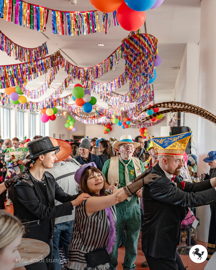 Personen feiern Fasching im Stuttgarter Rathaus mit einer Polonaise.