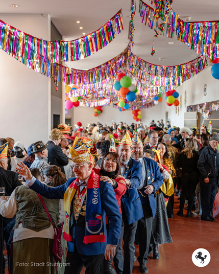 Personen feiern Fasching im Stuttgarter Rathaus mit einer Polonaise.