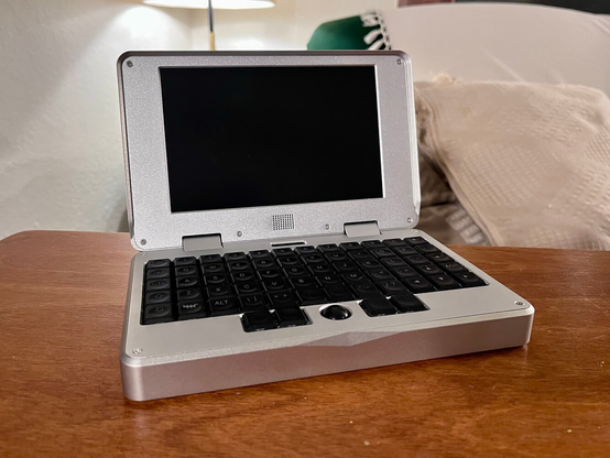 an open silver colored mnt pocket reform with the screen off on a table