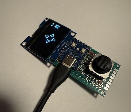 A micro controller soldered to a pcb together with a mini joystick and an oled screen. The display shows for arrows and some coordinates.