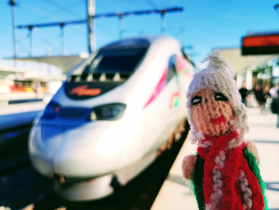 Picture of a finger puppet standing at the pointy end of an ONCF Al Boraq train.