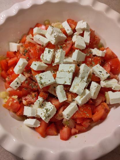Nachdem die Schalotten und der Knoblauch im Öl im heiß werdenden Ofen gezogen sind, kommt ser Feta, Tomaten und Gewürze dazu.