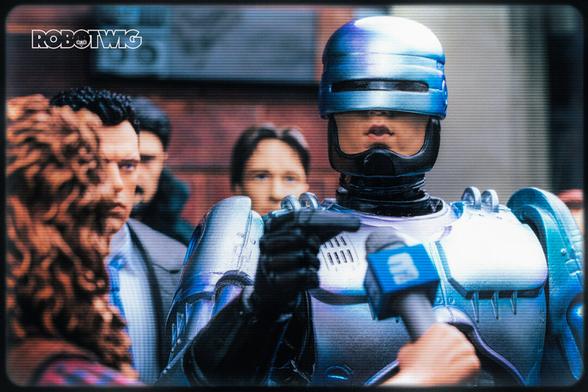 Robocop getting interviewed in the street by a newscaster crowd of people are watching behind