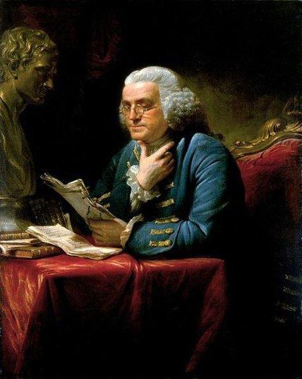 Ein historisches Gemälde Benjamin Franklins, der eine Brille trägt. Er sitzt an einem Tisch, auf dem Schriftstücke liegen, und hält ein Dokument in der Hand. Neben ihm steht eine Büste eines männlichen Kopfes. Er trägt eine elegante Jacke mit Goldverzierungen und hat eine nachdenkliche Miene.