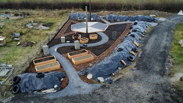 Drone photo of curvey garden with raised beds and plastic mulching