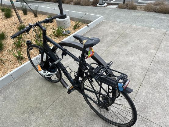 Bicycle with a panier rack over the rear well. The rack has an extra panier holder on top, horizontal in the middle.