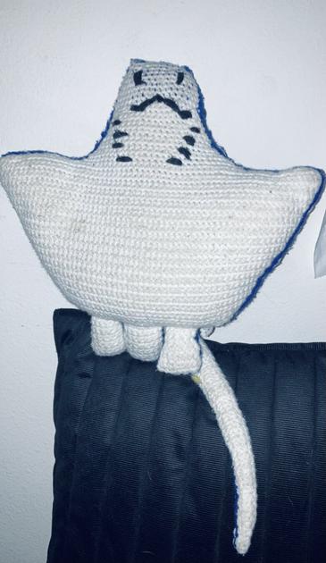 Top shot of the bottom of the plush showinng a white underbelly with black embroidery for the mouth and gills.