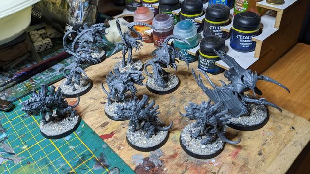 Lot's of unpainted plastic miniatures on a workbench.