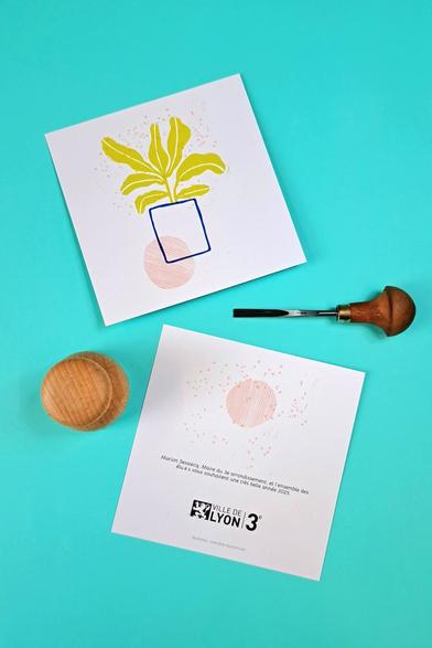 Carte représentant une plante en pot, réalisée en linogravure. Outils de gravure sur la photo