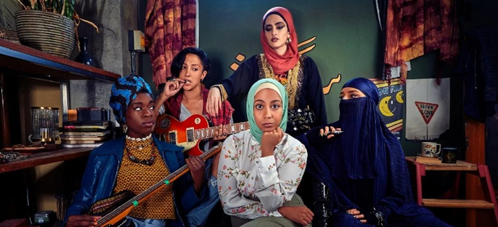 Elenco de las 5 protagonistas de We Are Ladyparts; rodeando a Amina (la protagonista principal) mientras la miran un poco de refilón.